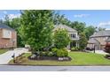 Beautiful home with lush landscaping, mature trees, and a well-maintained lawn at 1980 Marcia Overlook Dr, Cumming, GA 30041