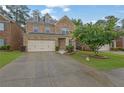 Two-story home with a brick facade, well-maintained lawn, and attached two-car garage at 7027 Walham Grv, Duluth, GA 30097