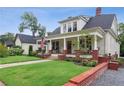 Charming two-story home with an inviting front porch, brick accents, and mature landscaping at 27 Sessions Nw St, Marietta, GA 30060