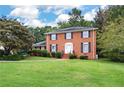 Charming two-story brick home featuring a lush green lawn and meticulously manicured landscaping at 3589 Stone Ridge Trl, Douglasville, GA 30134