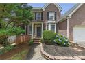 Front entrance of brick home featuring a covered entryway and manicured shrubs at 4815 Rapids Nw Cir, Acworth, GA 30102