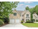 Charming two-story home with a well-manicured lawn, two-car garage, and neutral stucco facade at 1921 Northbrooke Ln, Dunwoody, GA 30338