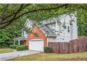 View of the side of a two-story home, showcasing the brick facade and attached garage at 2711 Brookefield Nw Ln, Kennesaw, GA 30152
