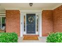 A welcoming front door with a wreath, flanked by sidelights and neat green shrubbery at 2711 Brookefield Nw Ln, Kennesaw, GA 30152