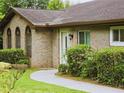 Close-up of the brick facade with arched windows and a well-manicured lawn at 2821 Ne Meadowlark Trail, Duluth, GA 30096