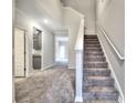 Inviting foyer with plush gray carpeting leading to an open floor plan and staircase with white banister at 335 Melody Ne Ln, Cartersville, GA 30121