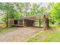 View of covered carport area with brick columns and concrete driveway leading to the house at 4078 Bouldercrest Rd, Ellenwood, GA 30294