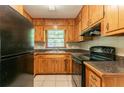 Functional kitchen with wood cabinets, laminate countertops, and black appliances at 4078 Bouldercrest Rd, Ellenwood, GA 30294