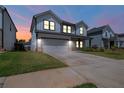Two-story home with welcoming glow, showcasing its well-manicured lawn at twilight at 4720 Dufour Dr, Lilburn, GA 30047