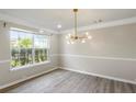 Bright dining room with wood floors, modern chandelier, and large window at 3385 Amhurst Pkwy, Atlanta, GA 30349