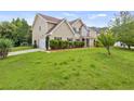 Tan two-story home with manicured lawn and mature trees in a suburban setting at 3385 Amhurst Pkwy, Atlanta, GA 30349