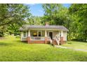 Charming home with a welcoming front porch, set on a well-manicured lawn with mature trees at 12728 Bells Ferry Rd, Canton, GA 30114