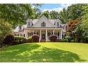 Beautiful two-story home featuring a large front yard, covered porch, and manicured landscaping at 220 Broadmoor Dr, Fayetteville, GA 30215
