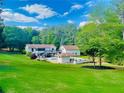 Expansive backyard with lush greenery, in ground pool, and pool house with outdoor kitchen at 345 Etheridge Rd, Auburn, GA 30011