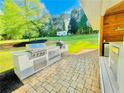 Full outdoor kitchen featuring a built-in grill, countertop space, and outdoor refrigerator at 345 Etheridge Rd, Auburn, GA 30011