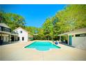An in-ground pool with concrete surround and detached covered lounge area at 345 Etheridge Rd, Auburn, GA 30011