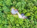 A lush tree canopy view reveals a home with a large driveway and two-car detached garage at 7212 Avalon Dr, Douglasville, GA 30135