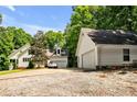 View of the home with driveway and detached two-car garage and lush surrounding trees at 7212 Avalon Dr, Douglasville, GA 30135