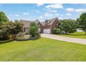 Brick home with green grass and mature trees and landscape at 4591 Millstone Walk Ne Dr, Buford, GA 30519