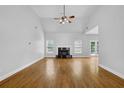 Living room with vaulted ceilings, fireplace, hardwood flooring, and plenty of windows at 4591 Millstone Walk Ne Dr, Buford, GA 30519