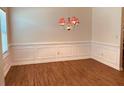 Elegant dining room featuring paneled walls, hardwood flooring, and a decorative chandelier at 5123 Upper Elm St, Atlanta, GA 30349