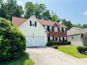 Attractive two-story home featuring a mix of brick and siding, a spacious driveway, and lush landscaping at 5123 Upper Elm St, Atlanta, GA 30349
