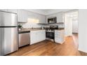 Well-lit kitchen with stainless steel appliances, granite countertops, and white cabinetry at 6 Stratford Hall Ne Pl, Atlanta, GA 30342