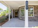 Welcoming front porch with stone accents, white columns, and a decorative house number at 895 Roxfield Ct, Buford, GA 30518