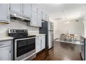 Bright kitchen featuring stainless steel appliances, gray cabinets, and hardwood floors to the dining area at 1828 Brandy Woods Se Dr, Conyers, GA 30013