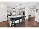 Modern kitchen boasts a center island with seating, pendant lighting, stainless appliances, and sleek gray cabinets at 209 Floral Valley Dr, Woodstock, GA 30188