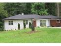 Quaint one-story home with a brick exterior, manicured bushes and a lush green lawn at 3175 West Manor Sw Cir, Atlanta, GA 30311