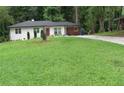 Attractive one-story brick home with a green lawn and a long driveway at 3175 West Manor Sw Cir, Atlanta, GA 30311