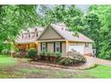 Charming home features a side-entry garage, landscaped garden beds and a cozy covered porch at 324 Kibbee Rd, Mcdonough, GA 30252
