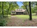 Inviting home with a large front lawn and screened-in porch, nestled among mature trees at 324 Kibbee Rd, Mcdonough, GA 30252