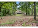 Secluded home surrounded by lush greenery, featuring a spacious front yard and a screened porch at 324 Kibbee Rd, Mcdonough, GA 30252
