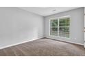 Bedroom with neutral walls, plush carpet, and natural light from a double window at 10073 Dorothy Ct, Jonesboro, GA 30236
