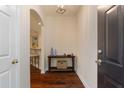 Inviting foyer with dark hardwood flooring, a console table, and an arched entryway to the living spaces at 2400 Cumberland Se Pkwy # 613, Atlanta, GA 30339