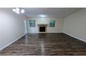 Spacious living room featuring a cozy stone fireplace, hardwood floors, neutral paint, and natural light at 5517 Green Wing Ct, Lithonia, GA 30058