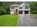 Charming split-level home with a two-car garage and freshly cut green lawn at 835 Navajo Trl, Covington, GA 30016