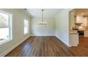 Dining area features wood-look floors, trim, and a modern chandelier, bathed in natural light at 96 Lexie Ct, Rockmart, GA 30153