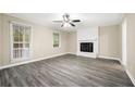 Bright living room with modern floors, a ceiling fan, and a striking white brick fireplace at 3521 Brookhill Cir, Marietta, GA 30062