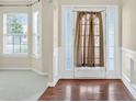 Bright foyer with hardwood floors, decorative molding, and a window-lined entry door at 910 Pebble Creek Trl, Suwanee, GA 30024