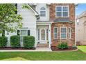 Inviting front entrance showcasing a decorative glass door, manicured bushes and stone exterior at 910 Pebble Creek Trl, Suwanee, GA 30024