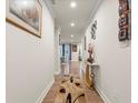 Long, bright hallway with hardwood floors and decorative wall art at 2456 Hidden Creek Rd, Kennesaw, GA 30152