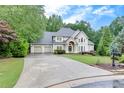 Beautiful home with a spacious driveway leading to a three-car garage and lovely front yard at 3028 Towneside Ln, Woodstock, GA 30189