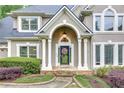 Inviting front entrance with stone pathway, columns, and a decorative wreath on the door at 3028 Towneside Ln, Woodstock, GA 30189
