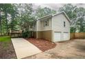 View of the house with a two-car garage and a well-maintained lawn at 4409 Woodward Mill Rd, Sugar Hill, GA 30518