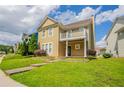 Inviting two-story home with a balcony, complemented by a lush green lawn and a serene neighborhood setting at 4567 Parkway Cir, Atlanta, GA 30349