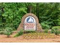 Stone sign for the Water's Edge community surrounded by lush landscaping and trees at 507 Cross Creek Pt, Stone Mountain, GA 30087