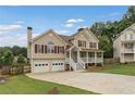 Two-story home with a welcoming front porch, attached two-car garage, and landscaped yard at 113 Westchester Xing, Canton, GA 30115